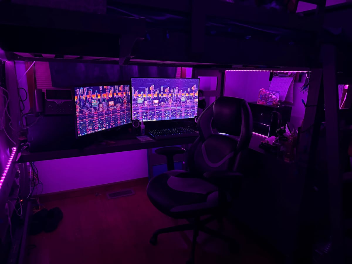A dual-monitor computer setup under a loft bed